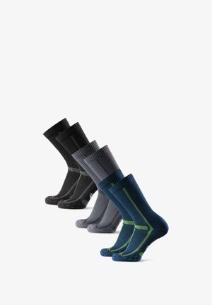 Quattro paia di calzini crew in nero, grigio scuro, grigio chiaro e blu navy, con texture a costine e diversi colori di accento.