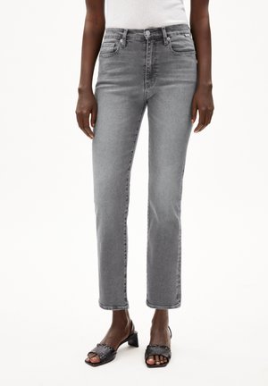 Person wearing high-waist straight-cut gray jeans and black open-toe block heel sandals, standing against a white background.