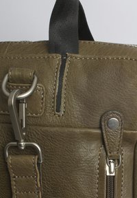 Olivgrüne Lederhandtasche mit strukturierter Oberfläche, ausgestattet mit einem zentralen Reißverschluss, metallicfarbenen Hardwareteilen und einem gewebten Textilriemen.