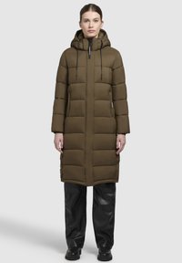 Olivegrøn pufferjakke med hætte, der har et quiltet design, frontlynlås, justerbare snore og sidelommer.