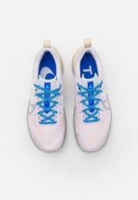 Baskets de sport roses claires avec des lacets et des accents bleus. Tige en mesh, design perforé, col rembourré et semelle grise texturée.