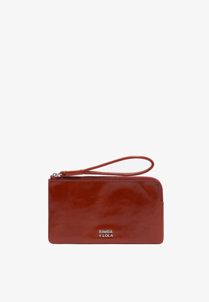 Červená kožená peňaženka so zipsom, obsahujúca zápästný remienok a strieborné embosované logo. Hladký povrch a obdĺžnikový tvar.