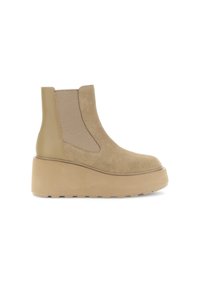Bottines en suede beige avec une épaisse semelle plateforme, des panneaux latéraux élastiques et un dos en cuir lisse. Surface texturée avec des lignes nettes.