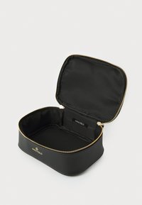 Estuche de cosméticos negro con cremallera, con un exterior texturizado y herrajes dorados. El interior está forrado en tela negra. Etiqueta de logo visible en el interior.