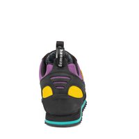 Chaussure d'escalade noire et violette avec des accents jaunes, en tissu texturé, semelle en caoutchouc et talon renforcé. Elle dispose d'une boucle pour un enfilage facile.