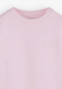 Sudadera rosa claro hecha de tela suave. Presenta un cuello redondo y puños acanalados. Sutil logo de "Scalpers" en una impresión tenue en el frente.