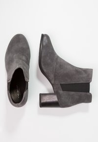 Botines de ante gris con tacón cuadrado, con paneles laterales elásticos para facilitar la puesta y un tacón texturizado para mayor detalle.