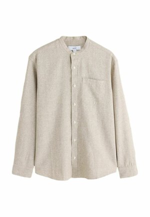 Chemise boutonnée beige clair en tissu texturé. Elle présente un col mao, des manches longues et une poche poitrine.