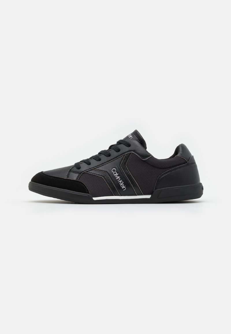 Baskets basses noires Calvin Klein avec lacets, tissu texturé et empiècements en cuir, avec le nom de la marque sur le côté et la languette.