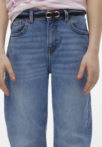 Jeans in denim blu chiaro con taglio dritto, caratterizzati da un classico design a cinque tasche e una cintura nera con una fibbia circolare di colore oro.