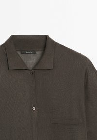 Dark brown button-up cardigan made of lightweight knit fabric. Featuring a pointed collar, one chest pocket, and a subtle textured pattern.