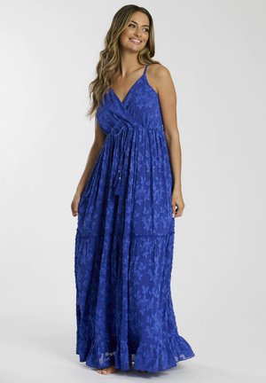 Abito maxi blu con spalline sottili, texture floreale e design a strati. Tessuto leggero che scende fino al pavimento con un orlo arricciato.