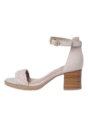 Sandale en daim beige avec boucle à la bride cheville, bride tissée à l'avant, semelle rembourrée et talon bloc empilé sur fond blanc.