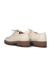 Beige leren schoenen met een lage hak, ronde neus en gestikte accenten. Voorzien van een lichtbruine rubberen zool en vetersluiting.