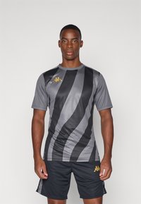 Grå og svart stripete treningsgenser med korte ermer, rund hals, og en gulllogo på venstre bryst. Kombinert med mørke shorts.