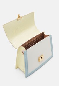 Sac à main rectangulaire avec devant blanc, bordure bleu clair et intérieur jaune pâle à texture crocodile, doté d'un fermoir doré et d'un rabat ouvert.