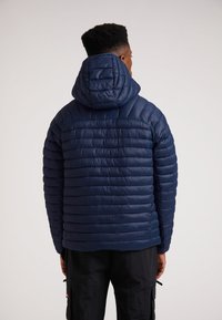 Mørkeblå pufferjakke med hætte, der har et horisontalt kviltet mønster og en glat tekstur. Designet til varme og lagdelt isolering.