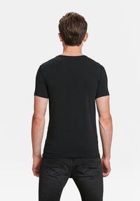 Zwarte korteblouse T-shirt van katoen. Eenvoudig ontwerp met ronde hals en een gladde textuur. Geen zichtbare logo's of patronen.