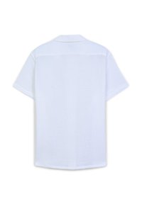 Camicetta a maniche corte con colletto in bianco, caratterizzata da un tessuto texturizzato, vestibilità rilassata e cuciture piatte. Dettaglio della spalla posteriore visibile.