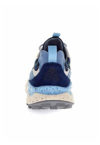 Vista posteriore di una sneaker con tomaia in suede blu e navy, suola intermedia beige maculata e linguetta del tallone blu chiaro. Suola testurizzata visibile.