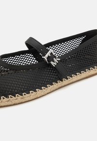 Chaussure Mary Jane en maille noire avec semelle en jute tissée et bride réglable avec boucle argentée et pendentif logo MK.