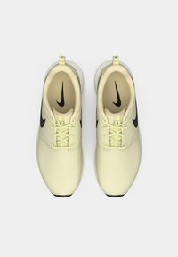 Αθλητικά παπούτσια ανοιχτού κίτρινου με μαύρες λεπτομέρειες, στρογγυλή μύτη και επίπεδη σόλα. Διαθέτουν κορδόνια και θηλιά στο πίσω μέρος. Κατασκευασμένα από λείο δέρμα.