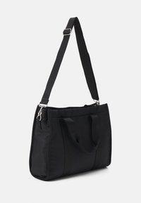 Sac fourre-tout en nylon noir avec deux poignées courtes et une longue bandoulière réglable. Présente un design simple et une texture lisse.