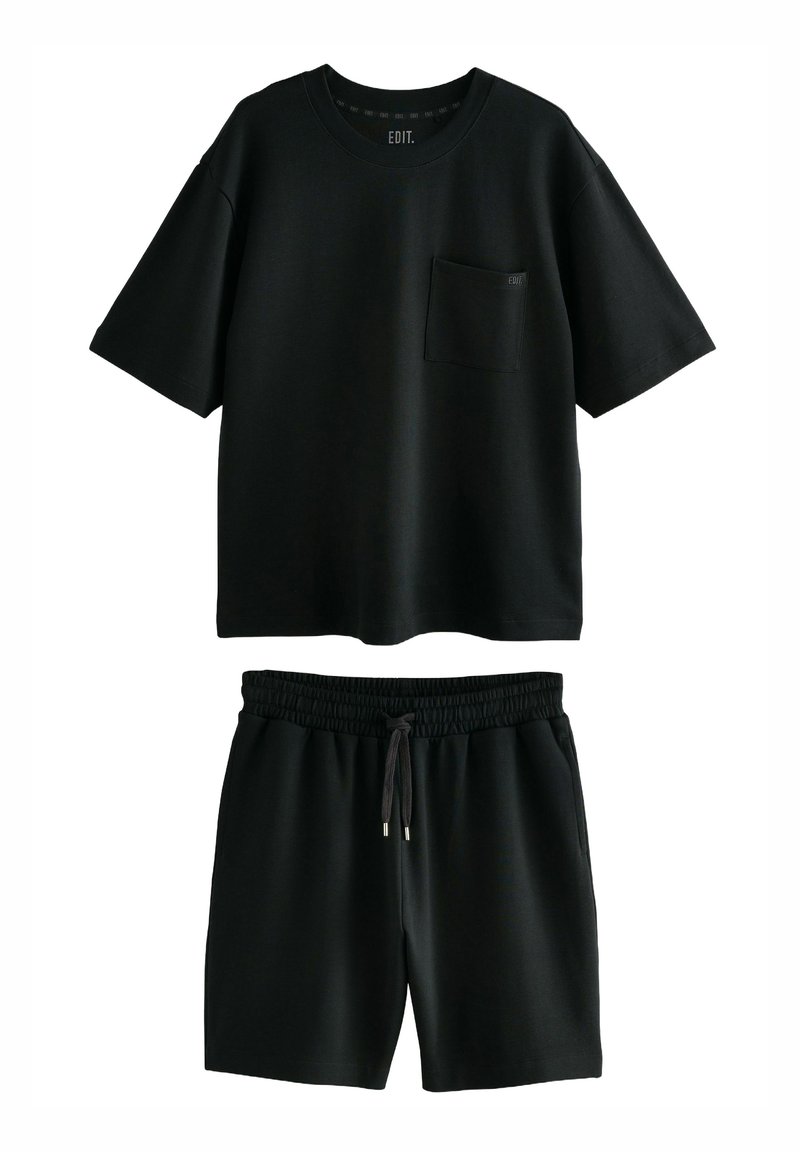 Sort kortærmet T-shirt og matchende shorts sæt, lavet af blødt stof. T-shirten har en brystlomme; shortsene har en elastisk talje.