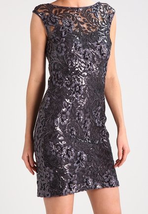 Robe noire sans manches ajustée avec dentelle florale et sequins, présentant un col transparent et une broderie complexe.