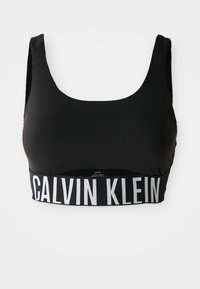Svart sports-bh med rund hals, bred elastisk kant med "CALVIN KLEIN" i hvitt, og teksturerte skulderstropper.