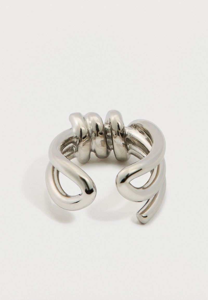 Silver metallic ring with a twisted, open design. Features smooth, rounded surfaces and three curved accents at the center.