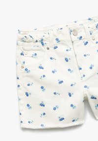 Hvide denimshorts med et blåt blomstermønster, som har en flettet talje og en riftet kant. Medfølgende metalknapper og lommer.