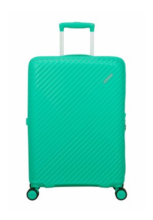Teal hard-shell suitcase with diagonal ridges, four spinner wheels, telescopic handle, and small "American Tourister" logo on front.