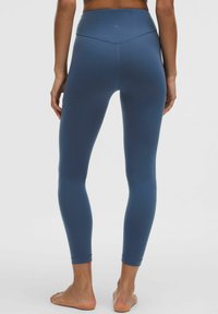 Augsta vidukļa zilas leggingas ar gludu, elastīgu audumu. Iezīmes bezšuvju dizains un pieguļošs piegriezums, kas sašaurinās pie potītēm.
