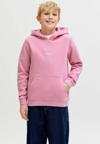 Lyserød hættetrøje lavet af blødt stof med en kængurulomme. Har en justerbar hætte og en lille hvid logo ved brystet.