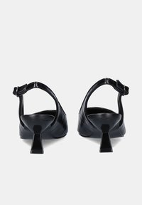 Sandalias de tacón de textil negro con una correa en el tobillo ajustable, un patrón texturizado de cocodrilo y tacones de bloque en forma cónica.