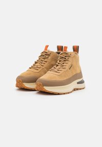 Beige Wildleder High-Top Sneakers mit strukturiertem Finish, kontrastierender brauner Gummisohle und orangefarbenen Akzent-Schlaufen. Abgerundete Zehenpartie und Schnürdesign.