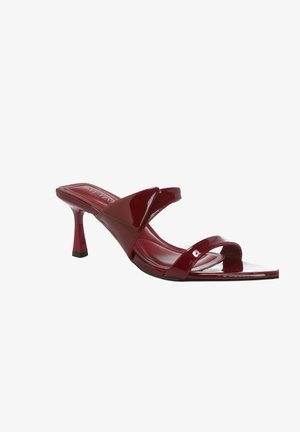 Czerwona sandałki typu mule z lakierowanej skóry z dwoma paskami i smukłym obcasem o średniej wysokości.