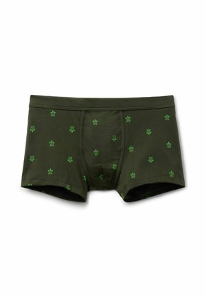 Mørkegrønne boxertrusser med små lysegrønne skildpadde mønstre jævnt fordelt på stoffet, lagt fladt på hvid baggrund.