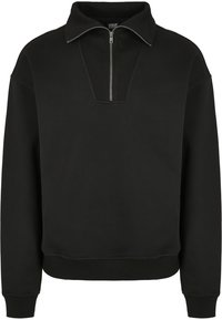 Hanorac negru dintr-un material moale, cu fermoar la jumătate și guler înalt. Include accente ribbed la guler și mansete.