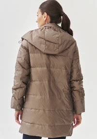 Gewatteerde, knie-lange jas in taupe met een capuchon, voorzien van horizontale stiksels en elastische manchetten. Materiaal lijkt glanzend en lichtgewicht te zijn.