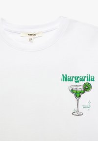 Witte katoenen t-shirt met een groene afbeelding van een margarita glas met limoen, de tekst "Margarita" en decoratieve sterren.