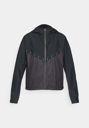 Black jacket with a hood, featuring a zip front, contrasting matte and glossy fabric, angled seams, and reflective accents on shoulders.