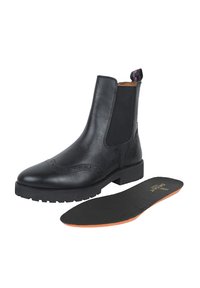 Bottines en cuir noir avec des panneaux latéraux élastiques, des détails en brogue et une semelle en caoutchouc épaisse. Comprend une semelle intérieure noire amovible avec des accents orange.