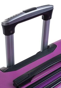 Maleta rígida con un cuerpo texturizado de color púrpura, acentos negros y un mango telescópico plateado, que cuenta con un agarre de goma y mecanismo de botón.