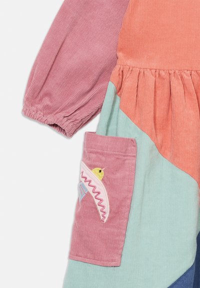 Corduroy dress featuring pink, orange, and teal sections, puffed sleeves, and a pocket with colorful bird embroidery. Textured fabric detail visible.