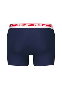 Námořnické modré boxerky vyrobené z měkké látky, s červeným a bílým elastickým páskem s logem 'PUMA'.