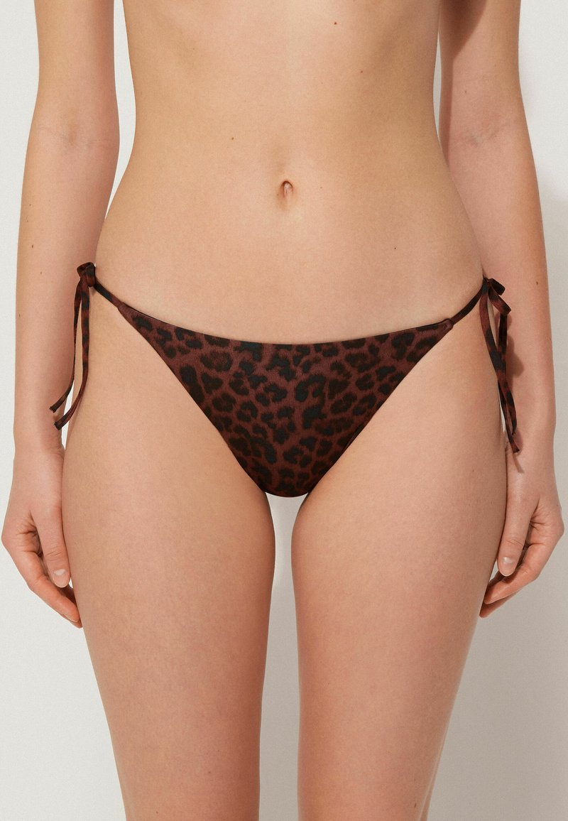Hnědé bikiny s leopardím vzorem na spodku s bočními šňůrkami. Mají hladký povrch a veselejší střih, ideální pro plavky.