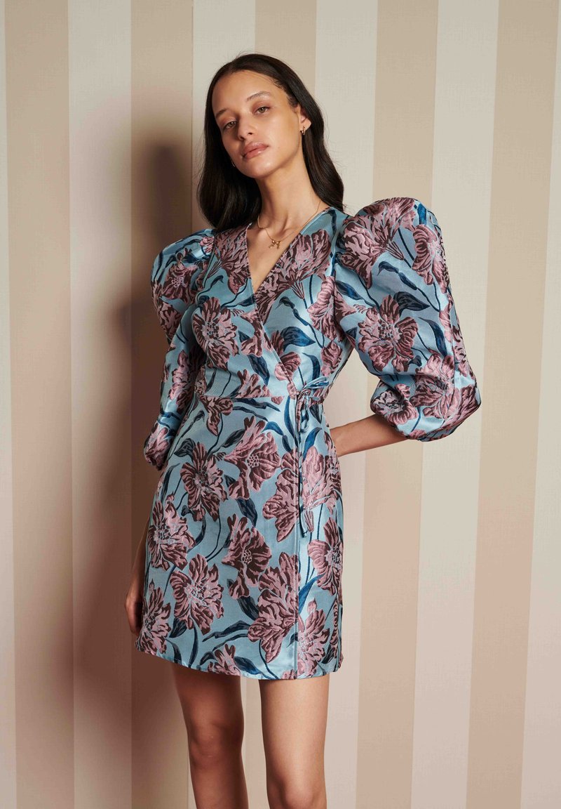 Φλοράλ φόρεμα τυλιγμένο σε ανοιχτό μπλε χρώμα με φουσκωτά μανίκια, διακοσμημένο με ροζ λουλουδάτο μοτίβο, υφασμάτινη υφή και εφαρμοστή σιλουέτα.