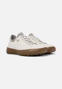 White leather sneakers with a lightly textured gray knit collar, tan rubber sole, and flat laces. Designed for comfort and casual wear.